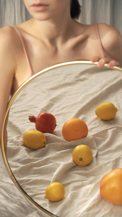 Woman Holding Mirror with Reflection of Fruits