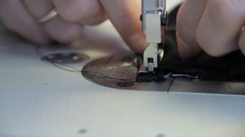 Female Hands Using Sewing Machine and Scissors