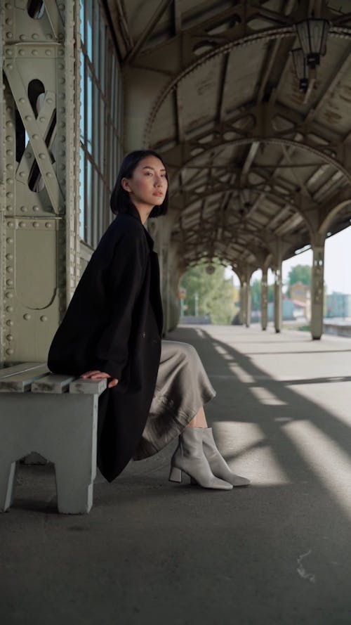 Woman Modeling Sitting in a Train Station 