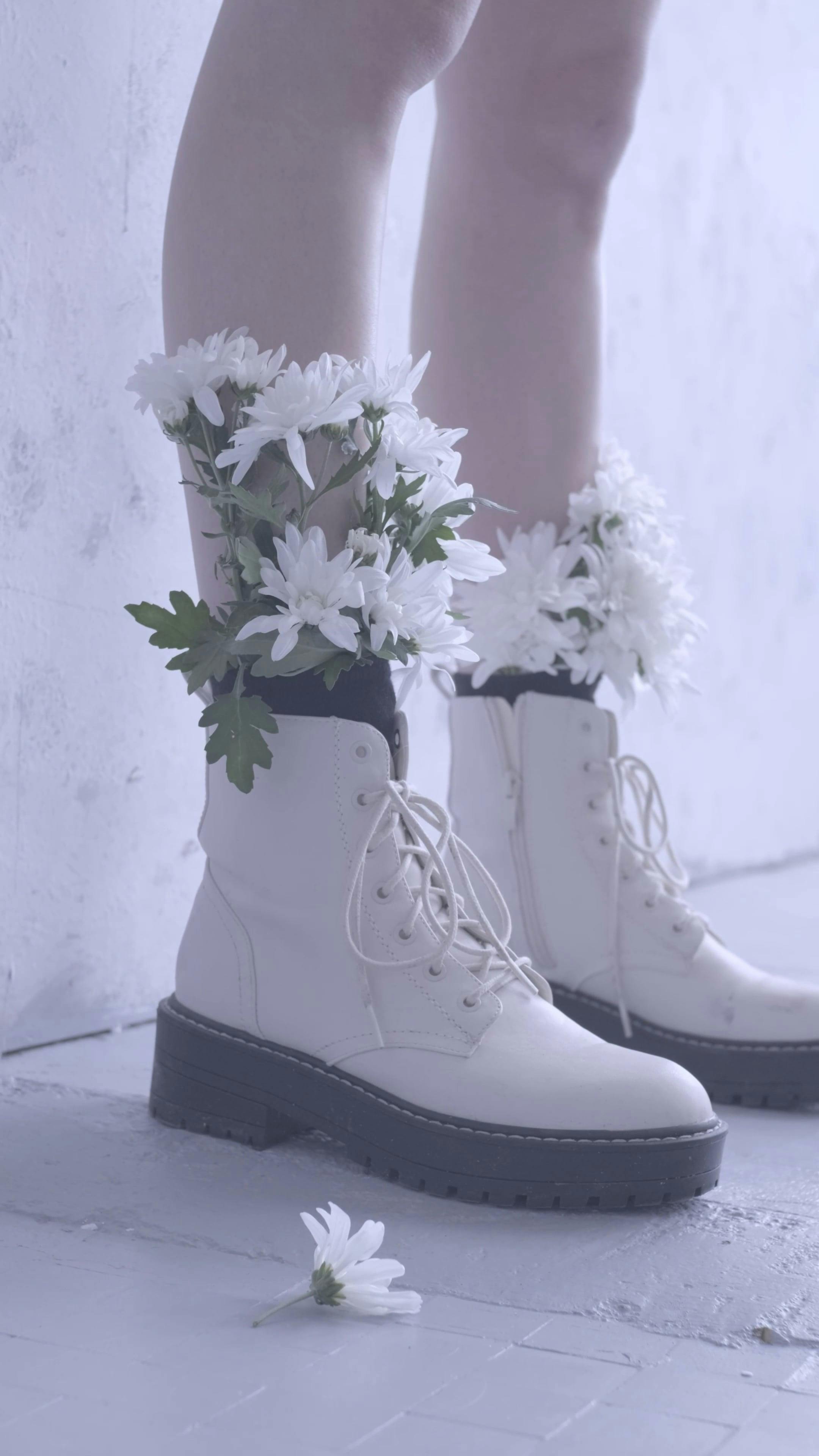 Person With White Flowers Inside the Boots Free Stock Video Footage