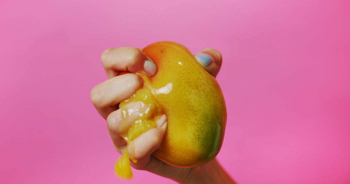 Close Up Shot of a Hand Squeezing a Ripe Mango Free Stock Video Footage ...