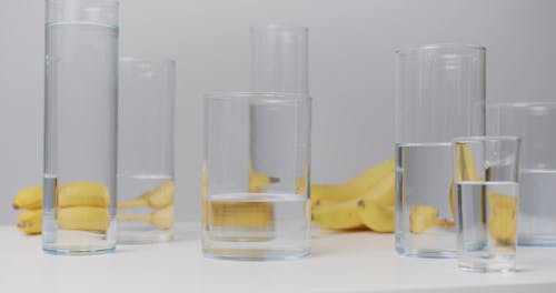 Water Glasses and Banana on White Table