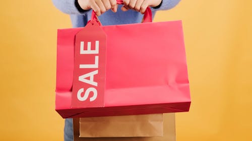 Tenant Des Sacs à Provisions Avec étiquette De Vente