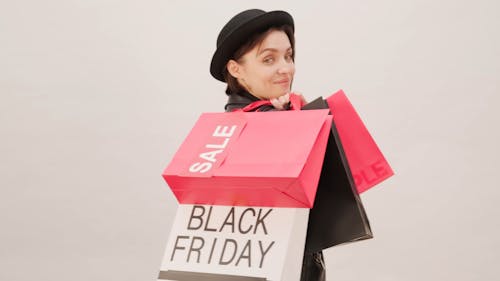 A Woman Hand Carrying Shopping Bags Over Her Shoulder