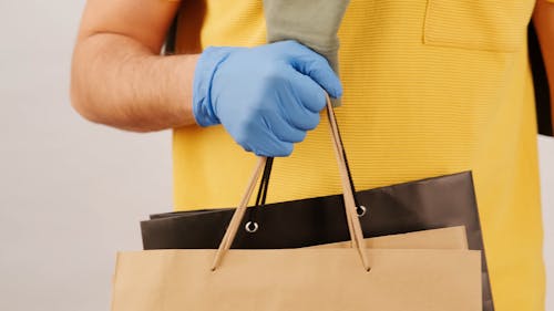 Un Hombre Con Guantes En El Transporte De Bolsas De La Compra.