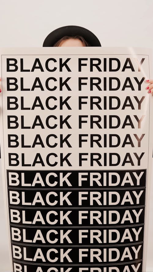 A Woman Holding A Black Friday Poster