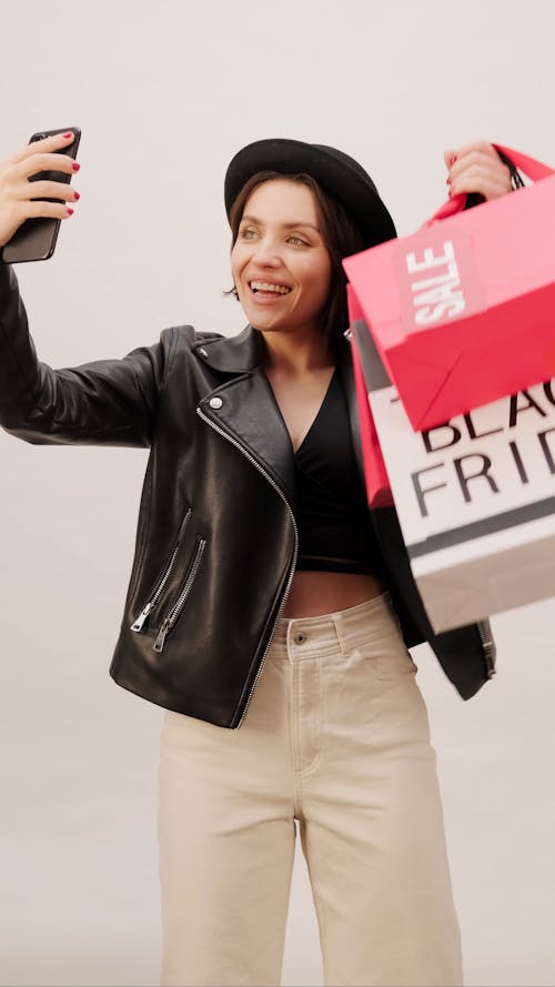 Eine Frau, Die Einkaufstaschen Hält, Während Selfie Nimmt