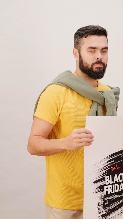 A Man Holding A Black Friday Sale Poster