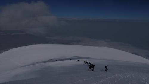 People Hiking a Snow Mountain