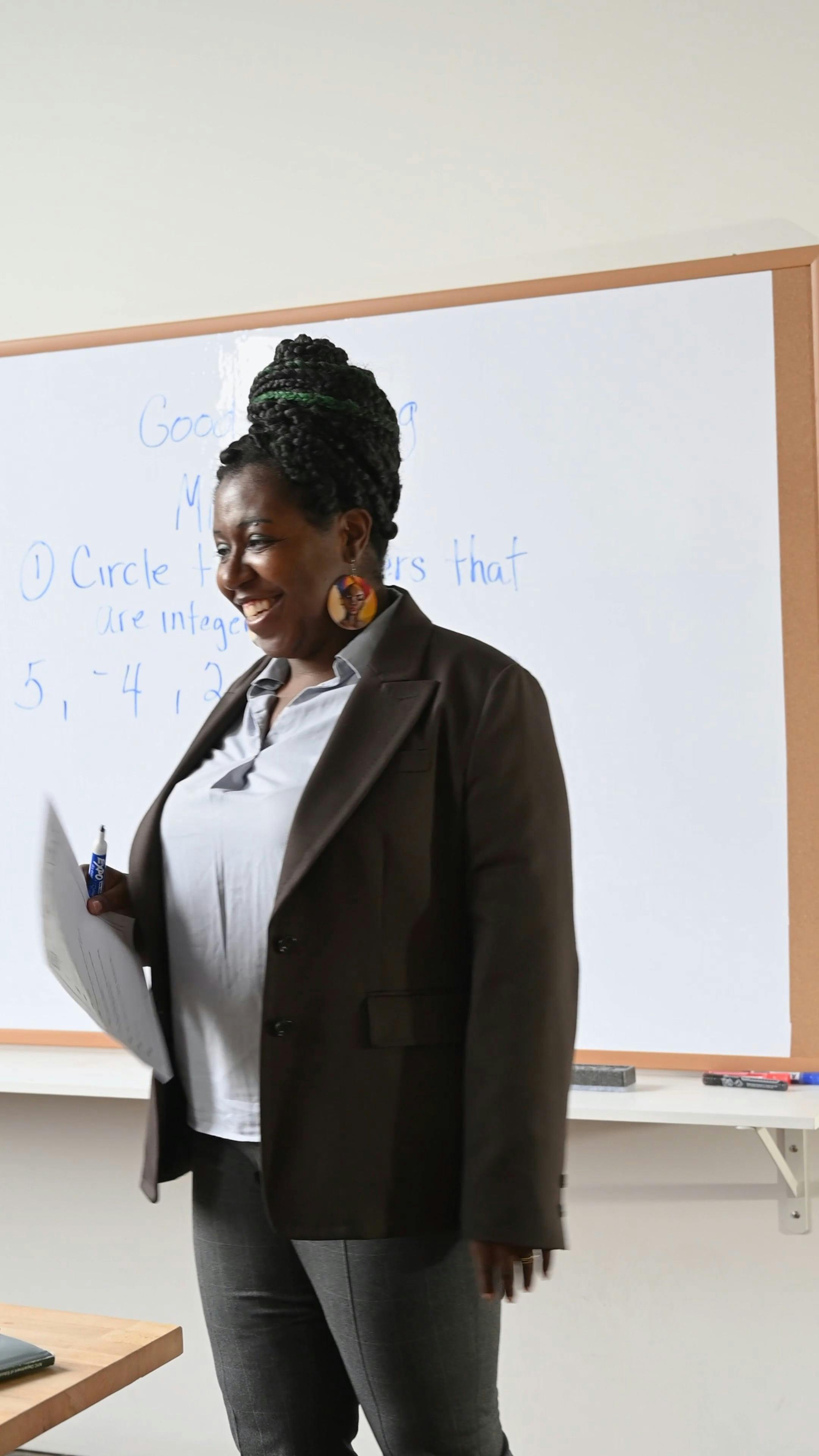Vertical Video of a Woman Wearing Coat and Holding a Paper Teaching in