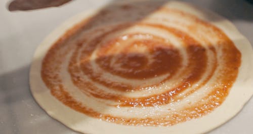 Chef Adding Mozzarella to Pizza Base