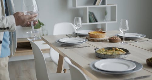 Person Putting Wine Glasses on the Table