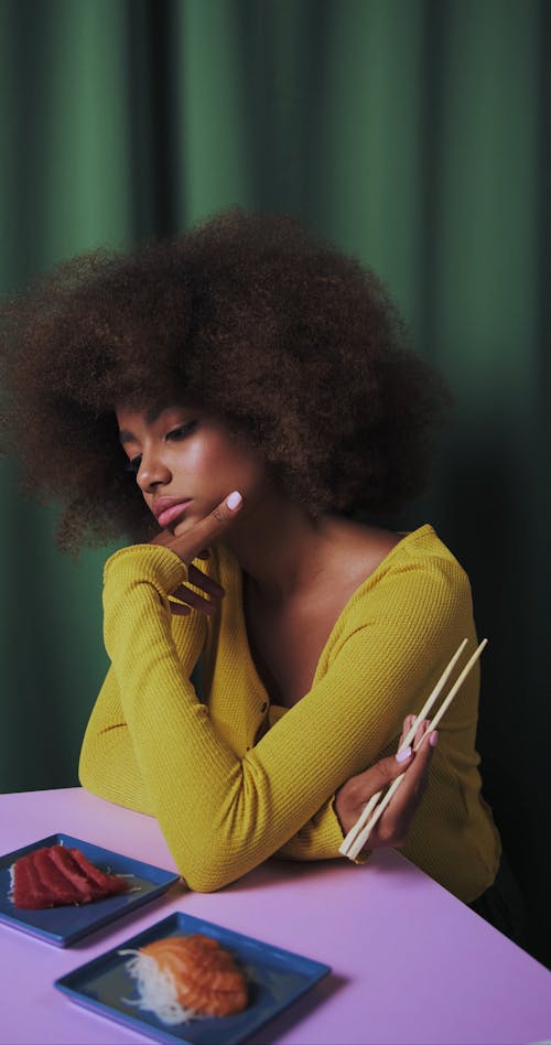 A Person at the Table Eating With Chopsticks