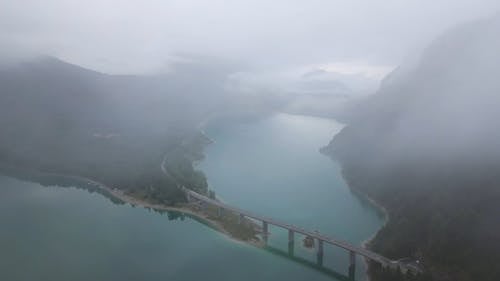 Drone Footage of Mountain Forest and a Bridge Above the Lake 