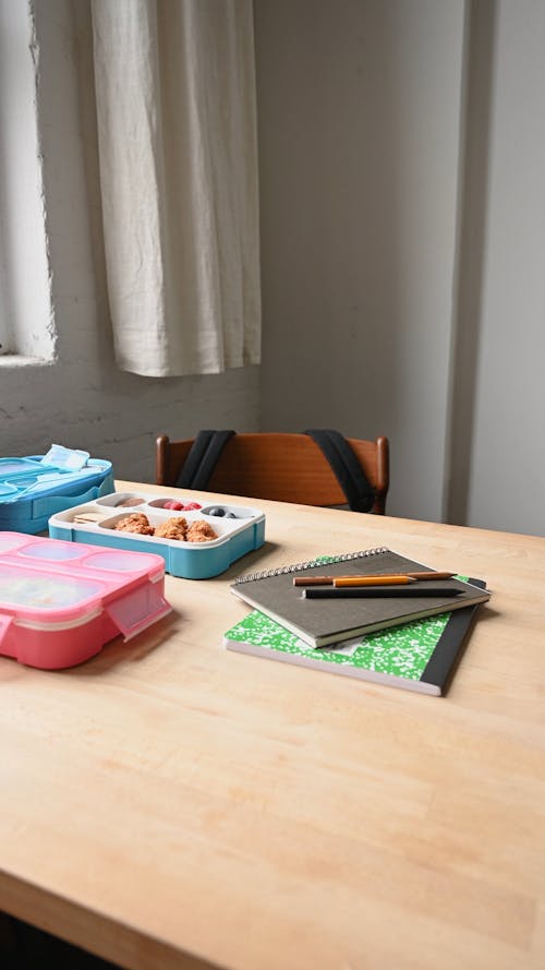 A Table With Notepads and Lunch Boxes