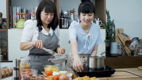 Mom and Daughter Cooking Noodles