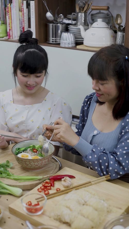 Mom and Daughter Eating Noodles 