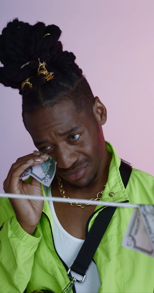 Man Wiping his Tears with Cash and Letting it Dry on String