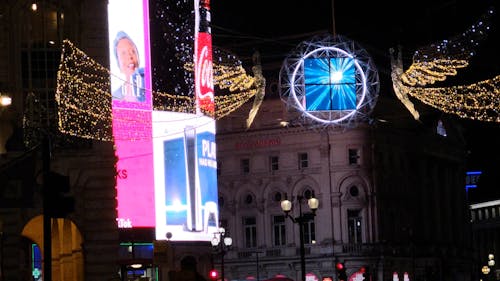 An Illuminated Billboard and Christmas Lights at Night