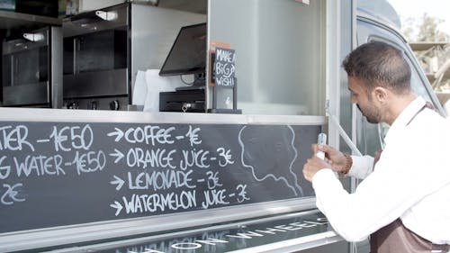 Food Truck Vendor Writing on the Menu Board