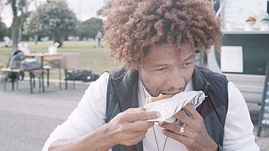 close up shot of a man eating a burger