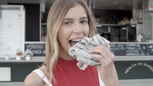 Blonde Female Eating a Burger with Colored Bun