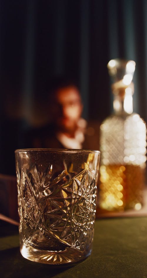 A person Pouring Whiskey on a Glass while Throwing Money