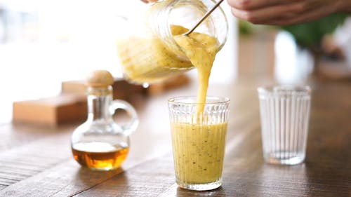 Person Pouring Smoothie in a Glass