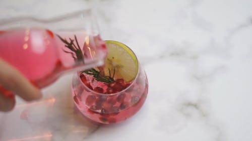 Pomegranate Cocktail with Lemon Slice Poured in a Glass