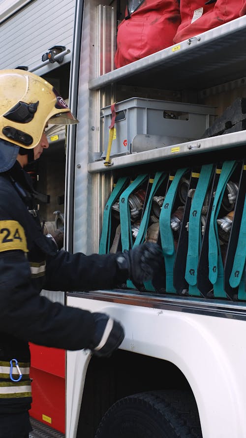 A Person Getting a Water Hose From a Fire Truck