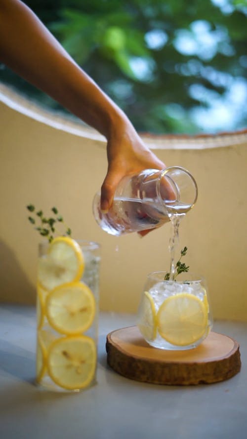 Liquid Being Poured on a Glass With Lemon