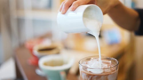 Pouring Milk on a Cold Beverage