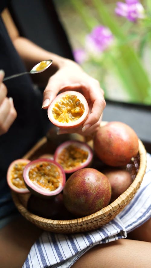Person Scooping Passion Fruits 