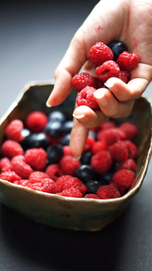 Filling a Bowl With Red Berries