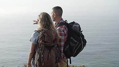 backpackers looking at sea