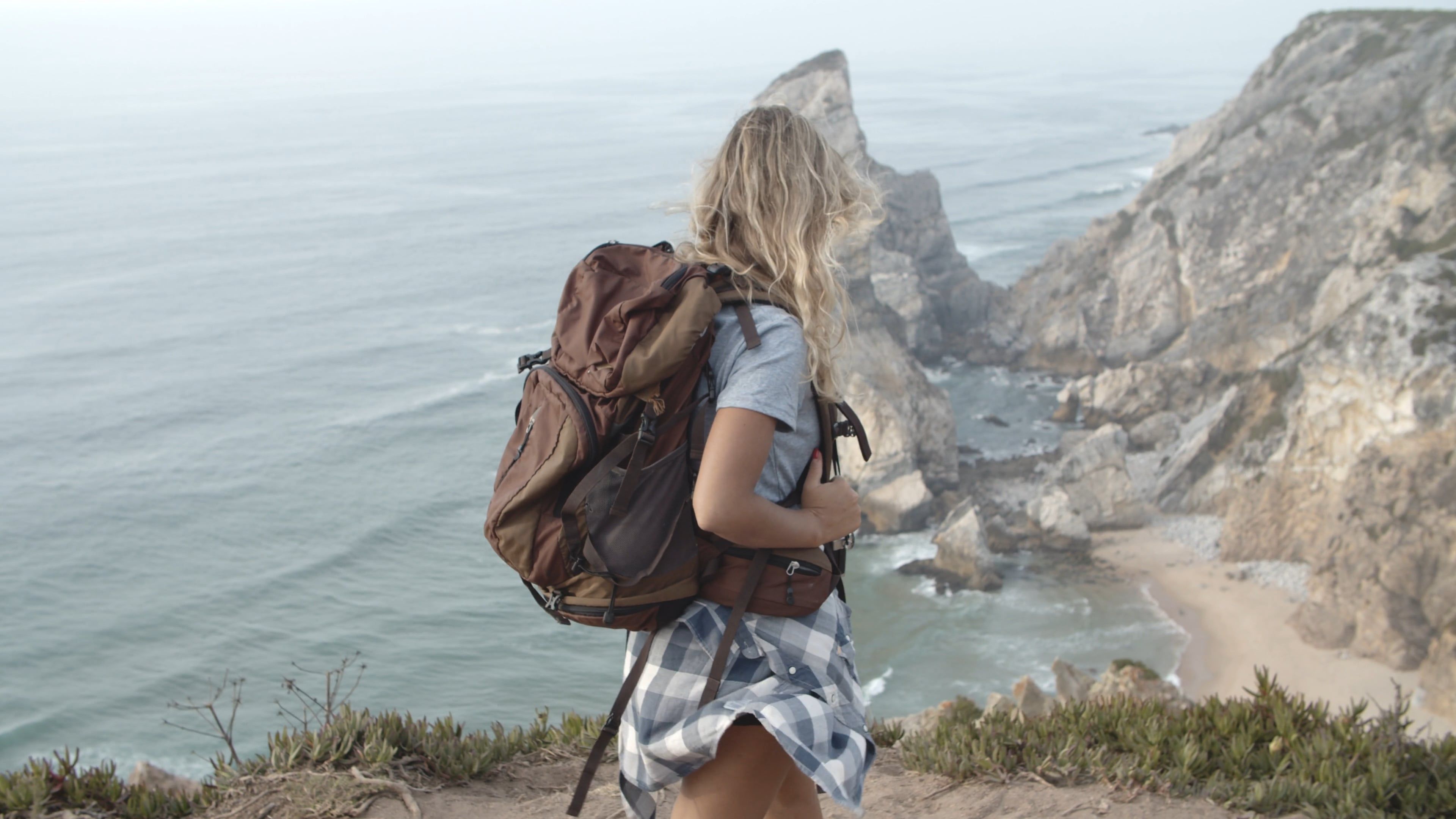 a woman walking on a cliff of a mountain 5945819