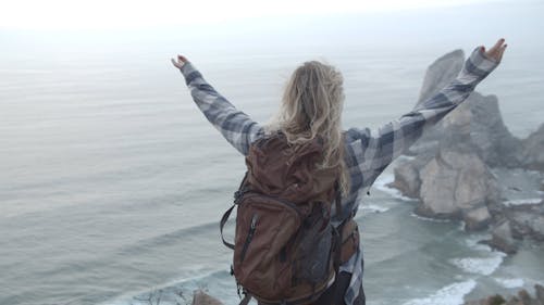 Woman Standing on a Cliff