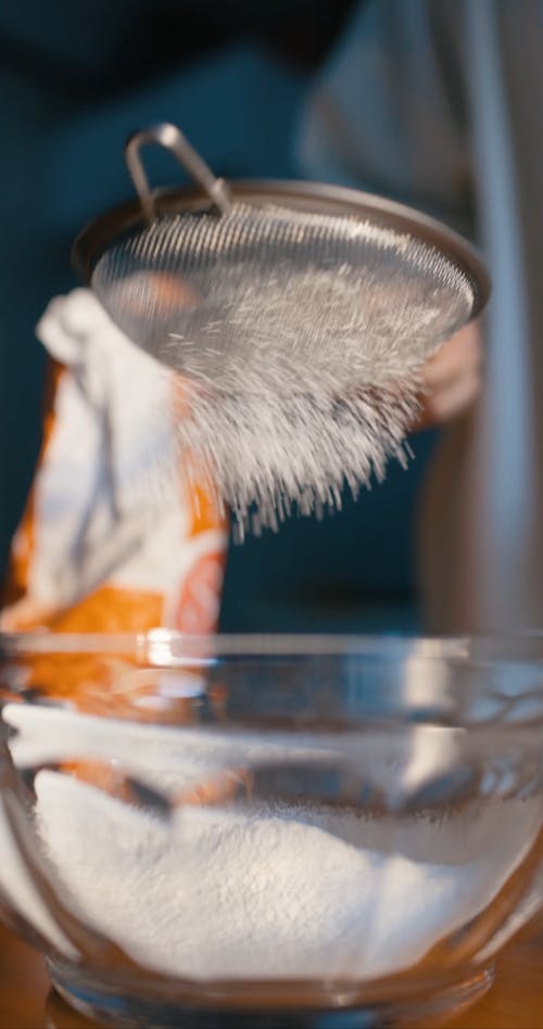 A Person Sifting Flour