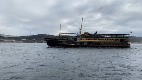 A Ferry Boat Sailing on Sea Under Cloudy Sky