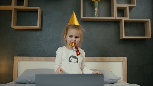 Little Girl Blowing Party Horns on Video Call