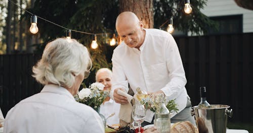 A Man Serving his Friend a Glass of White Wine