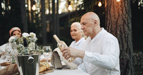 A Man Trying White Wine at a Dinner Party 