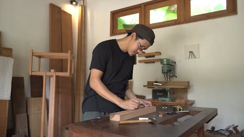 A Man Putting Markings on the Wood