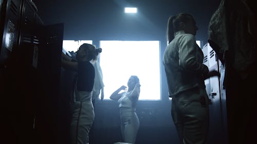 Women Wearing their Fencing Uniform un the Locker Room