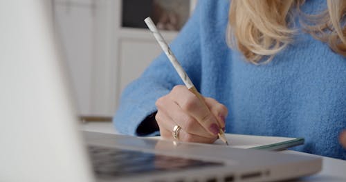 Close-Up Video of Hands Writing While Holding a Glass of Water