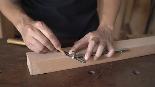 A Man Marking A Lumber Wood