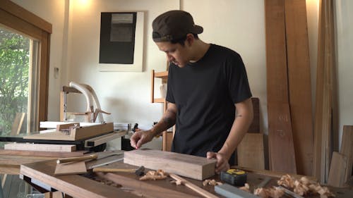 A Man Marking a Lumber Wood