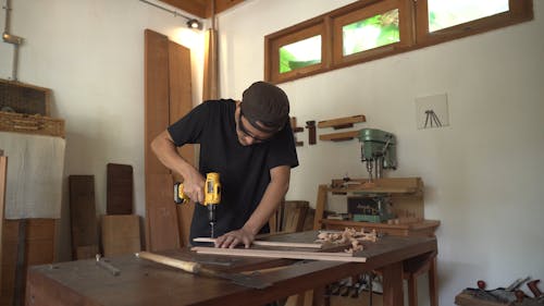 Een Man Met Behulp Van Een Boormachine Om Gaten Te Maken