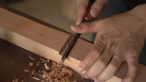 A Person Using a Chisel on Wood