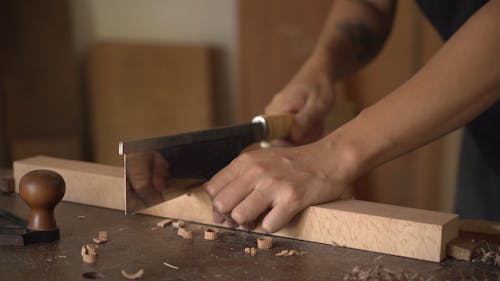 A Carpenter Using a Hand Saw